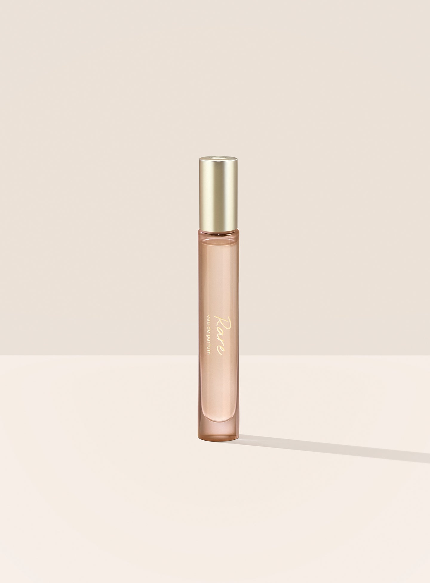 The Rare Eau de Parfum Travel Spray features a tubular bottle with a gold cap and script writing.